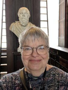 Selfie of Davida in front of portrait bust of Socrates at the Old Library at Trinity College, Dublin